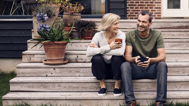 Couple smiling together at home in garden.