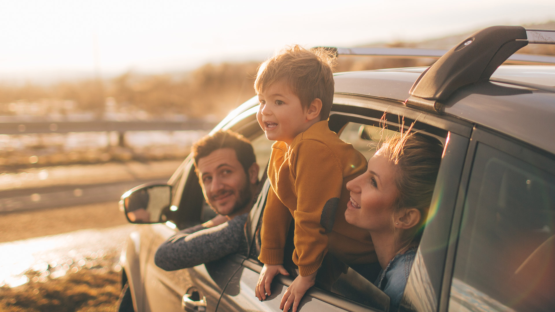 family in car kid leaning out of window