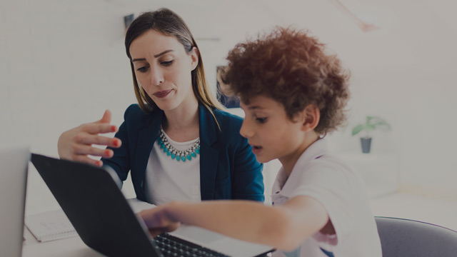 Woman teaching a child in front of a computer small overlay