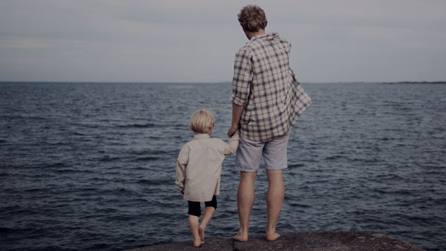 father and son looking at the ocean small overlay